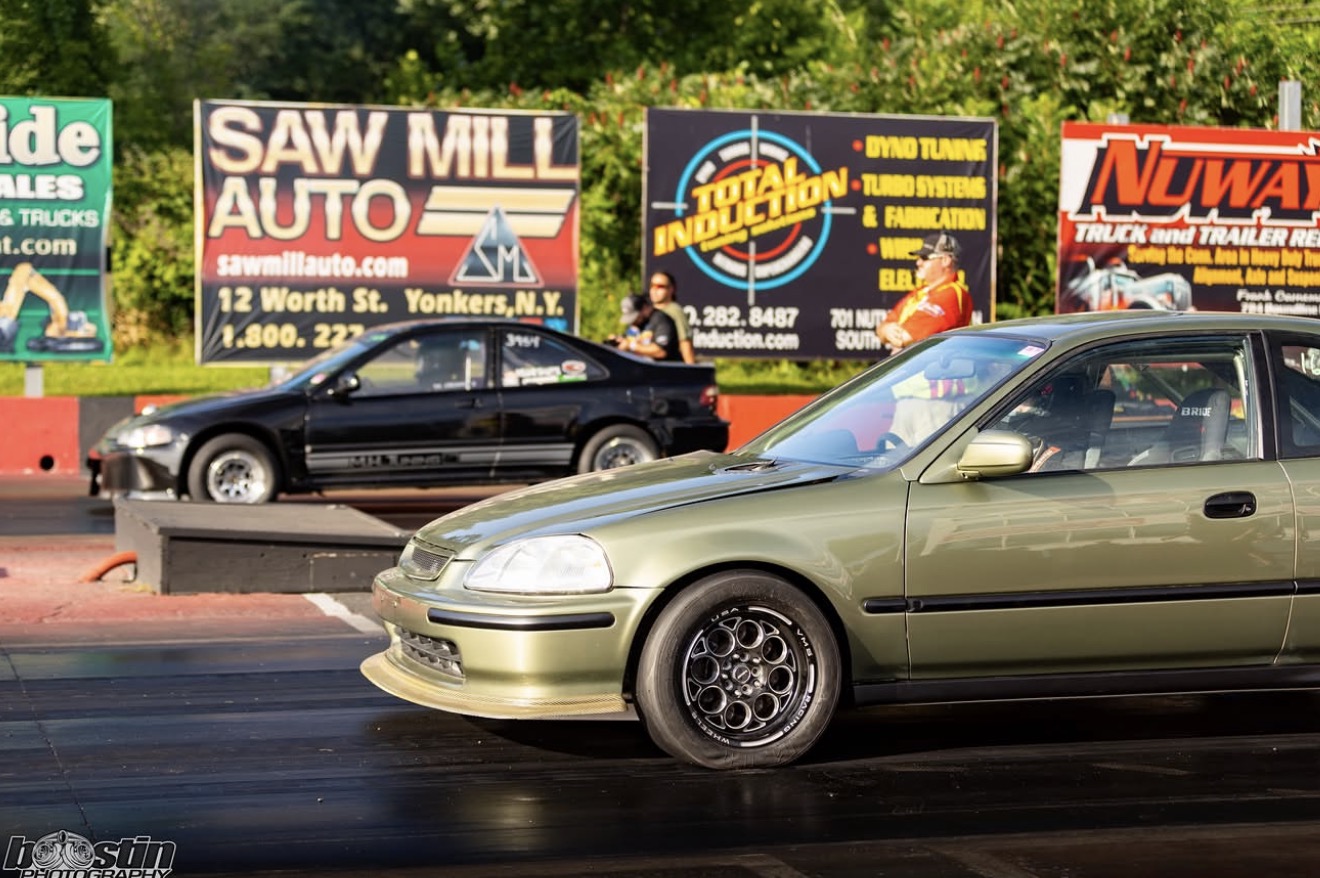 Green Honda hatchback launching from the starting line