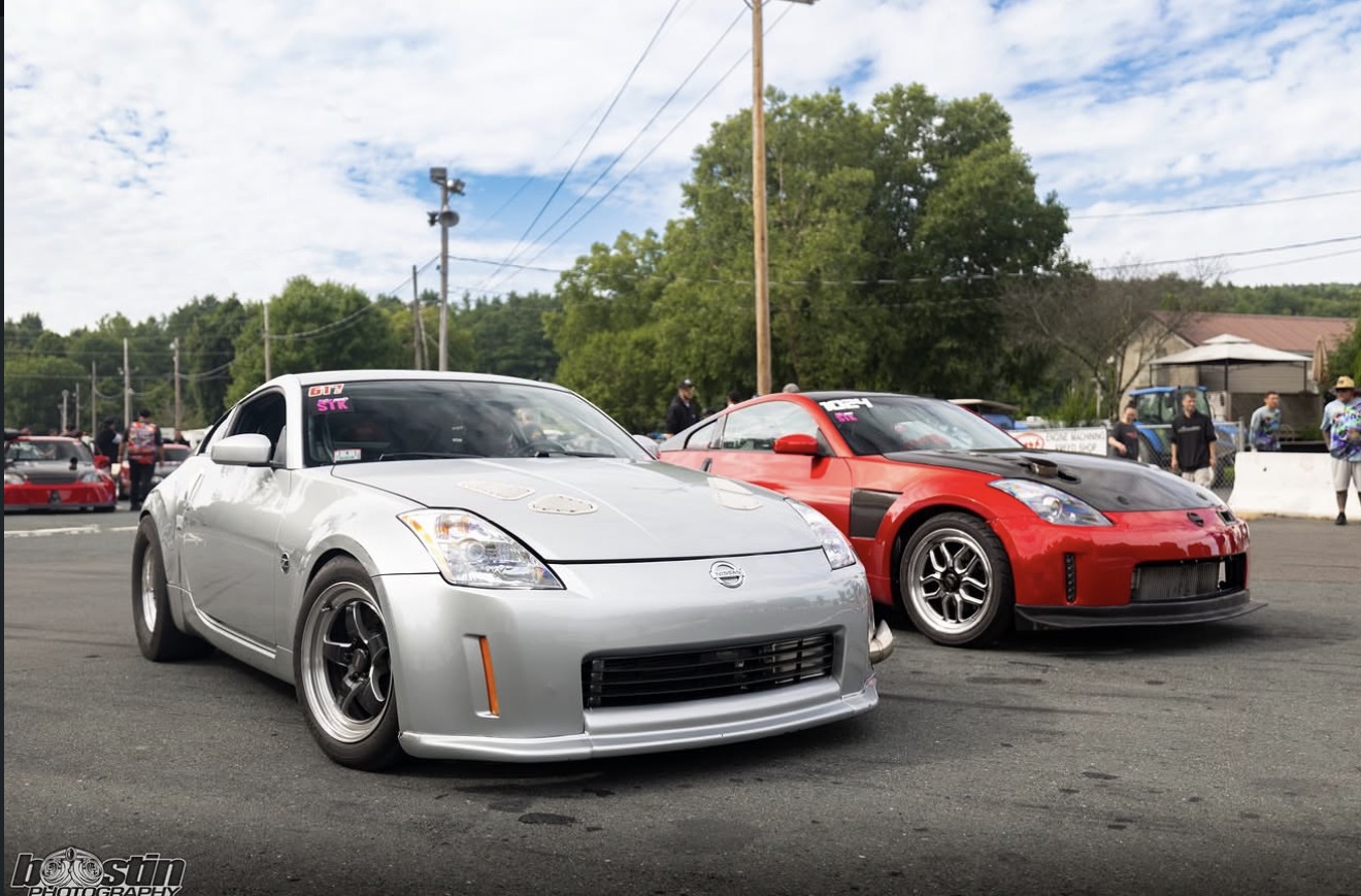Two Nissan Z race cars in the paddock