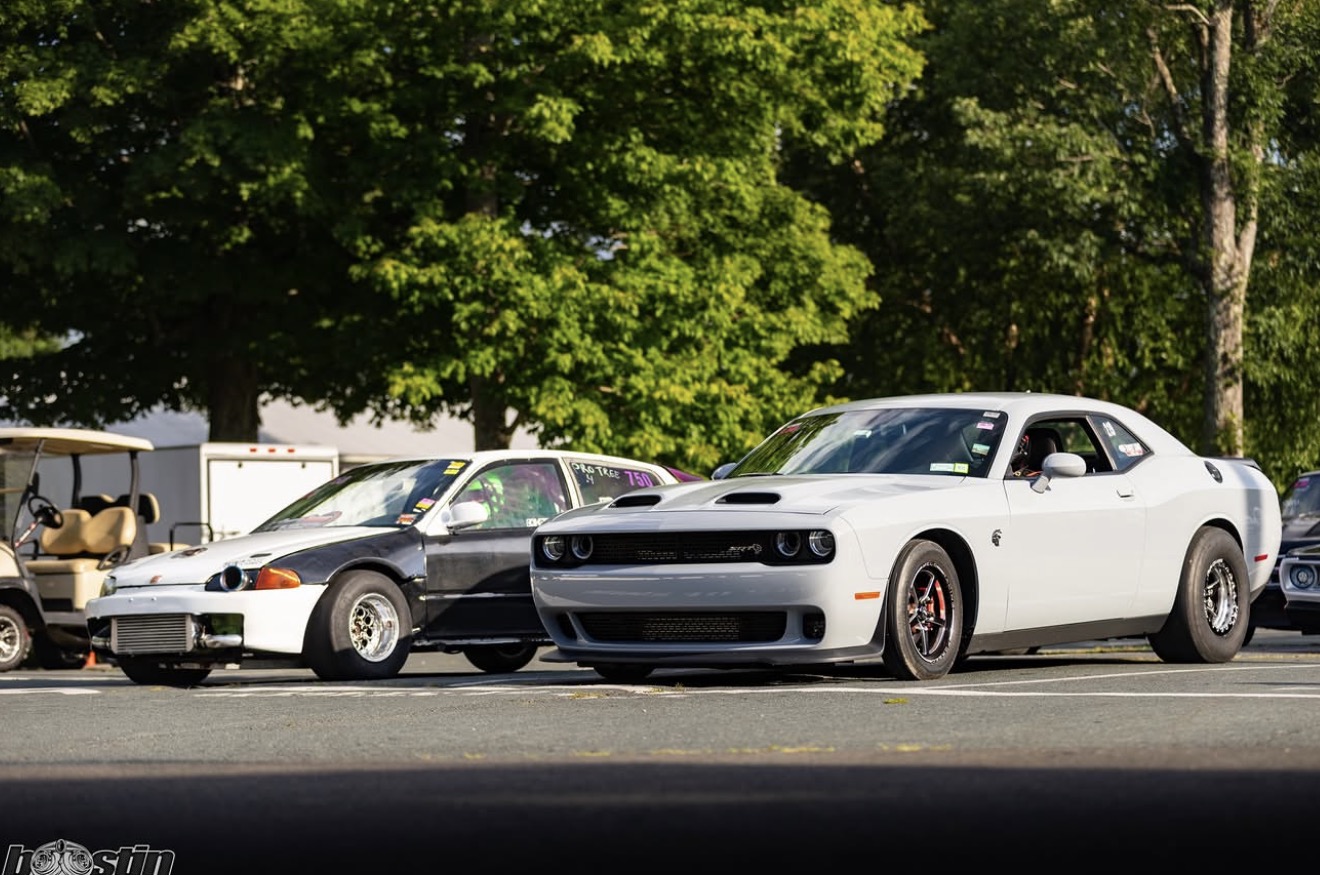 White Dodge Challenger lined up with import race cars